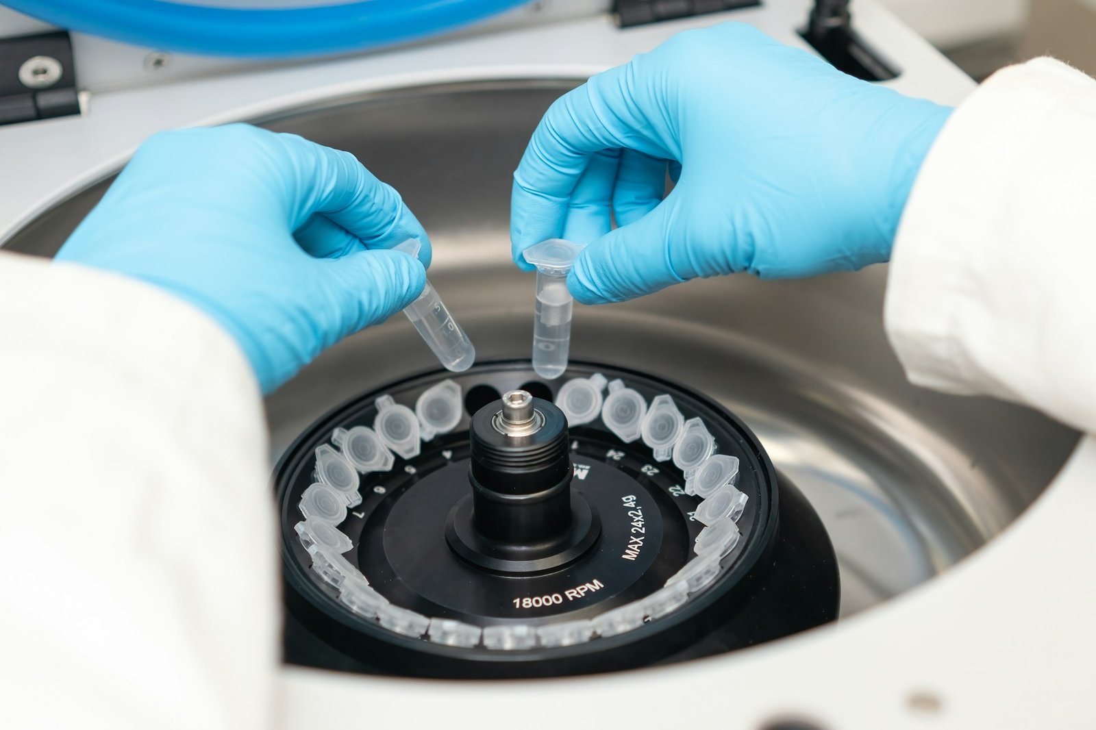 Laboratory worker puts chemical tubes into the centrifuge.