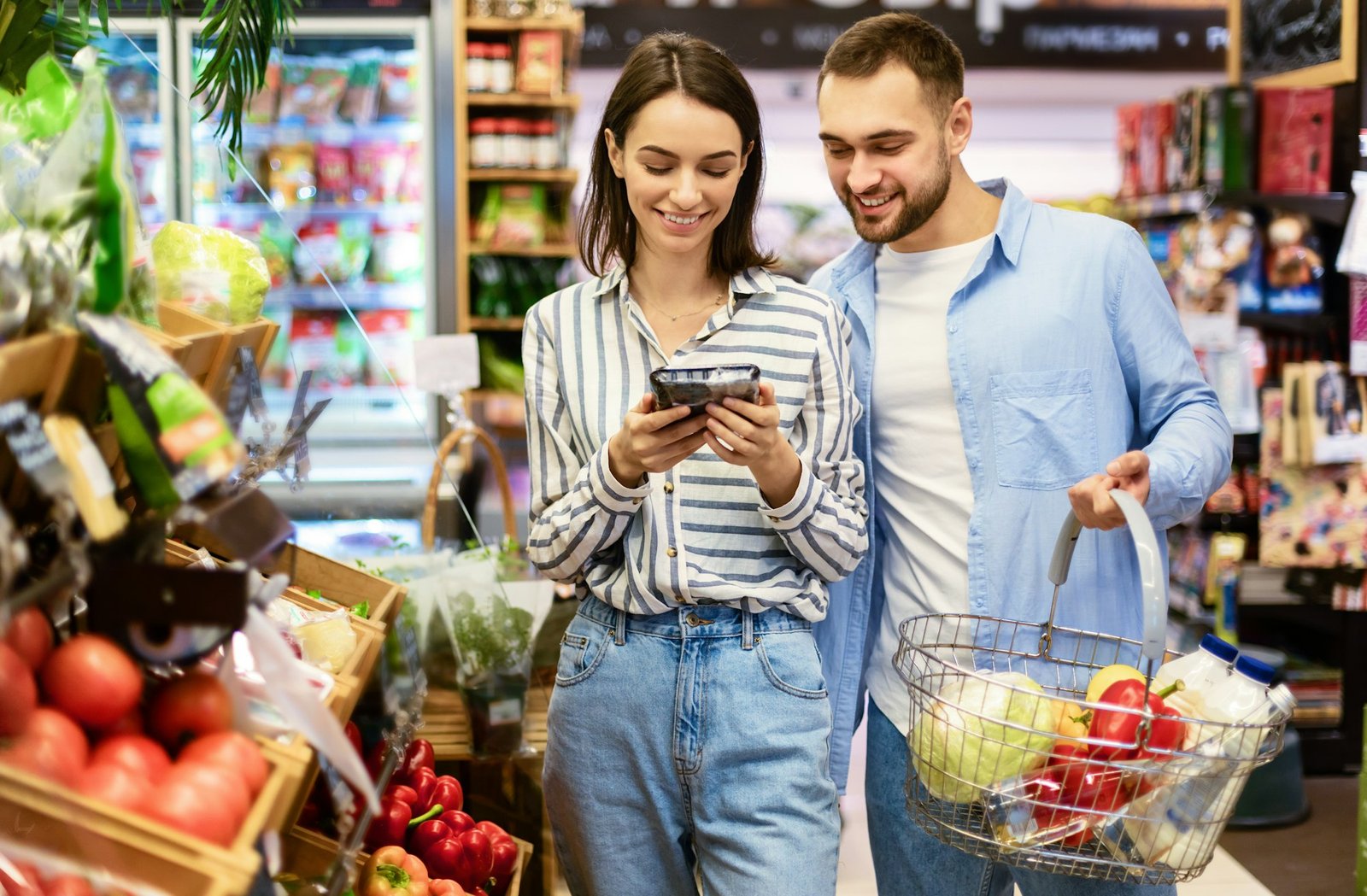 Young couple with the cart shopping in supermarket